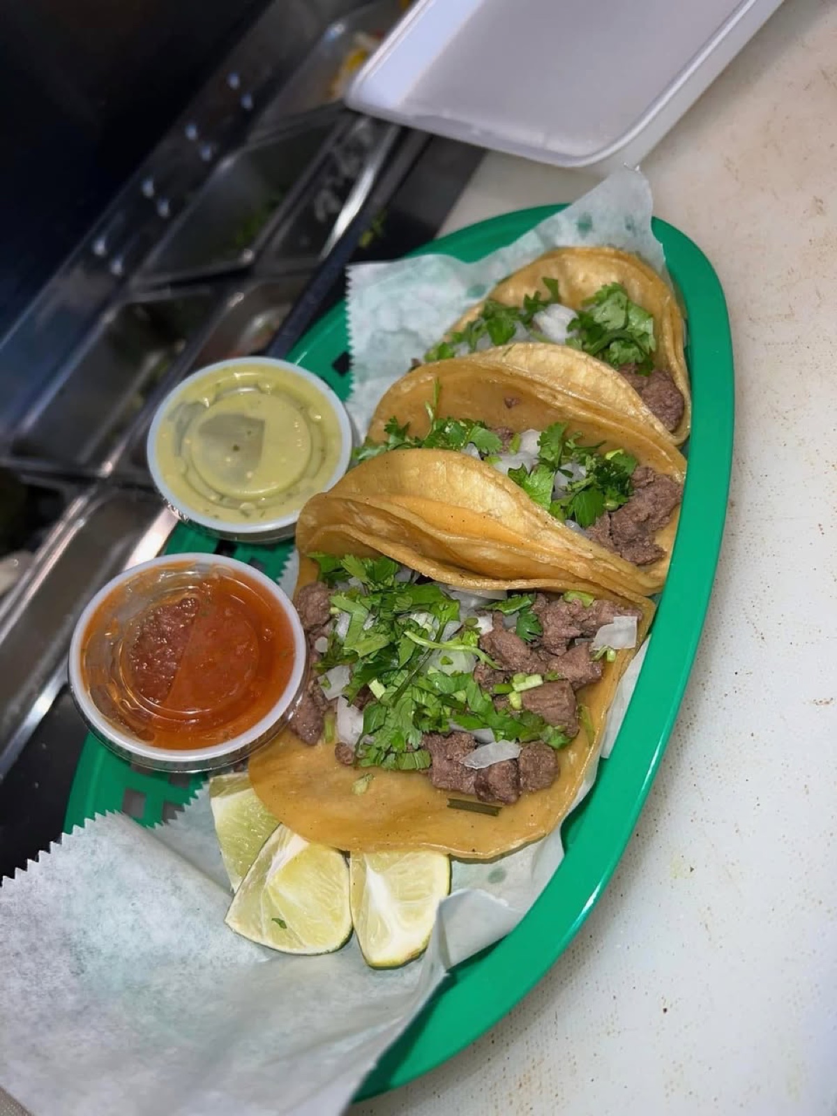Three street tacos — choice of meat on warm corn tortillas with onion and cilantro, salsa verde, salsa roja and fresh lime